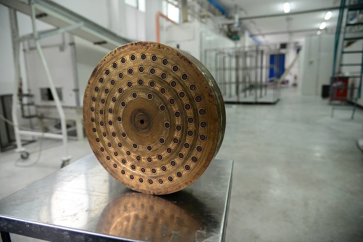 Runde Bronzeform mit vielen Öffnungen in einer Pasta-Manufaktur