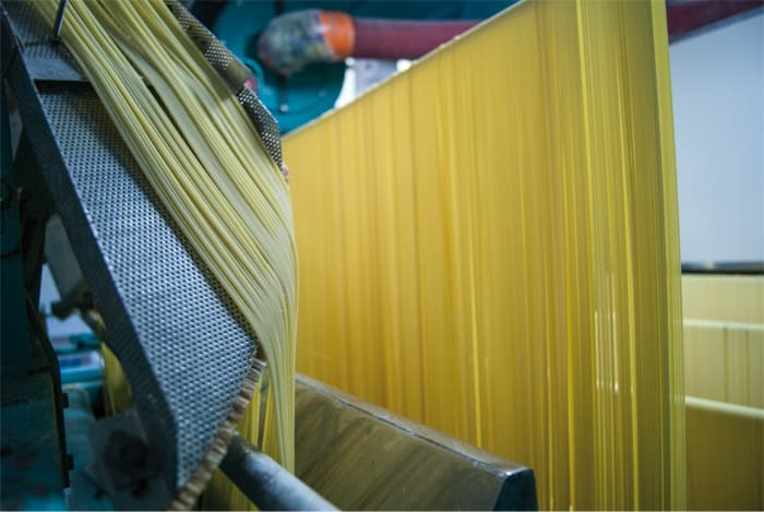 Lange Pasta hängt zum Trocknen auf Stangen